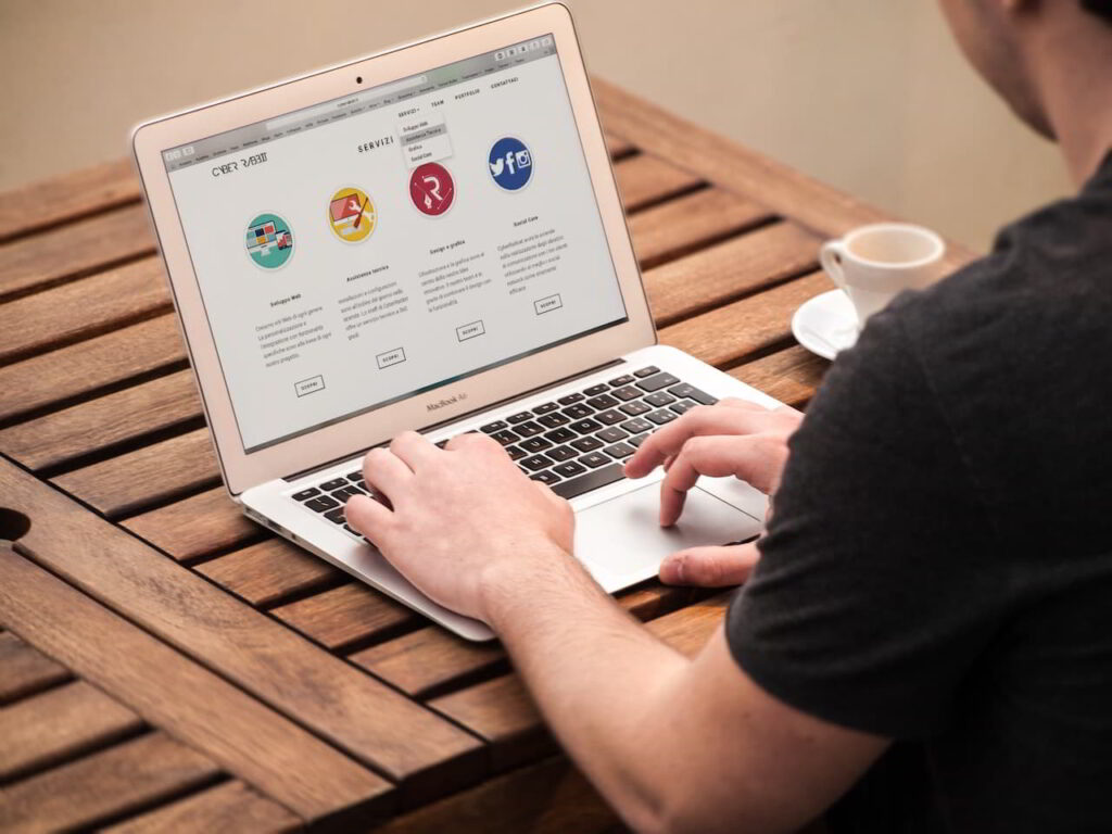 Man working on a laptop on a wooden office desk